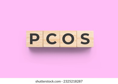 PCOS (Polycystic Ovary Syndrome) wooden cubes on pink background - Shutterstock ID 2325218287