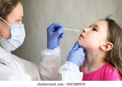 PCR Test And Kid, Nurse Holds Swab For Nasal Sample From Child. Doctor In PPE Suit Examines Little Girl Due To COVID-19 Or Monkey Pox. Concept Of Corona And Smallpox Virus, Kid, School And Monkeypox.