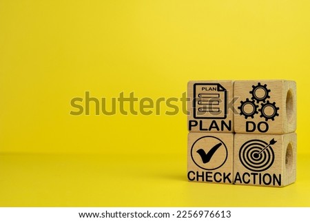 PDCA cycle,PLAN DO CHECK ACTION quality tool for business idea.,,PDCA (plan do check action) word and icon on wooden cube with copyspace over yellow background use for background,wallpaper,banner.