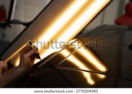 PDR Tap Down Knockdown Technique. PDR technician uses a precision knockdown punch and a wooden hammer to level metal high spots.