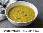 Pea and ham soup on grey counter - photo