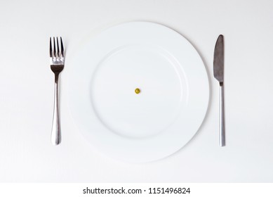 Pea On Plate. Knife And Fork. Isolated Background. Top Vew. Unhealthy Nutrition And Diets. Anorexia Concept. Equipment For Food. Teen Anorexic. Stainless Silver Set. Table On Studio.