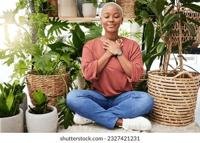 Peace, breathe and calm woman by plants for meditation exercise in a greenery nursery. Health, gratitude and young African female person with a relaxing zen mindset by an indoor greenhouse garden. - Powered by Shutterstock