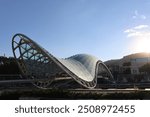 Peace Bridge in Georgia at sunset against the background of mountains