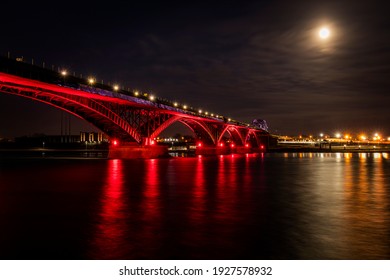 Peace Bridge Near Buffalo, New York State At A Full Moon Night, Illuminated In Red Colours