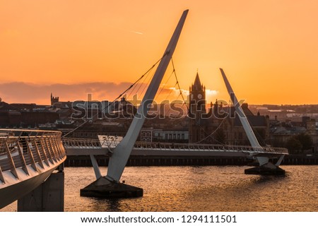 Peace bridge over the river foyle and guildhall in Derry Londonderry Northern Ireland