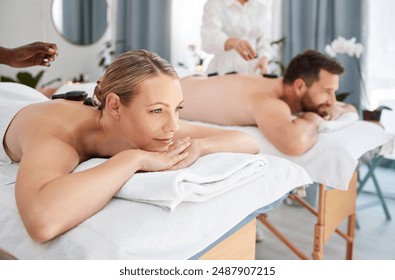 Peace, couple and spa for hot stone massage, relax on holiday and wellness with weekend break, smile and stress relief. Honeymoon, man and woman with vacation, rocks and time together with luxury - Powered by Shutterstock