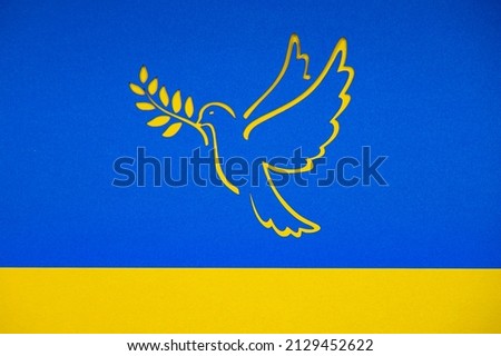 Peace in Ukraine in War after Attack from Russia. Dove as a symbol of peace. On a yellow-blue background in the colors of the Ukrainian national flag. Papercut