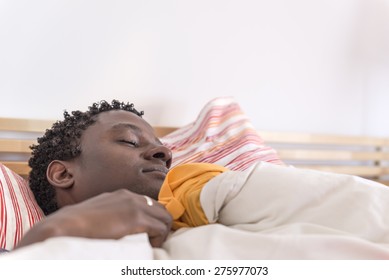 Peaceful african american man sleeping in bed at home in the bedroom