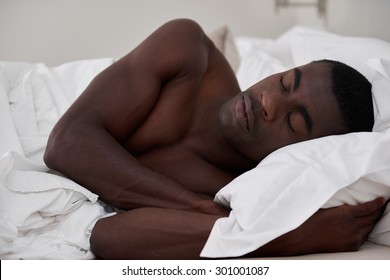 peaceful african black man sleeping comfortably in bed at home