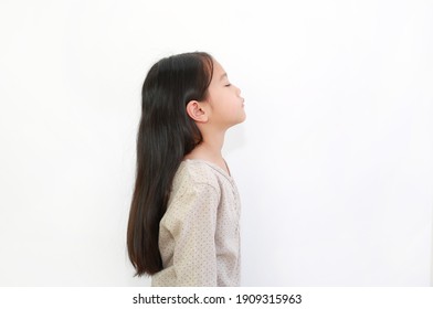 Peaceful Asian Little Girl Closed Eyes And Raise Head Up Isolated On White Background. Portrait Of Kid With Long Black Hair, Side View