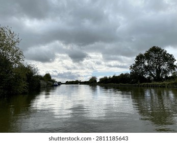 Peaceful Autumn Canal With Dramatic Cloud Formation And Water Reflections