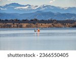 A peaceful Autumn day at Cherry Creek State Park, in Colorado with Sailboats on the lake and the Mountains visible in the background.