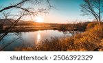 A peaceful autumn sunset over a lake in the forest. A feeling of coziness, calm, happiness, freedom and relaxation. An escape from the hustle and bustle.