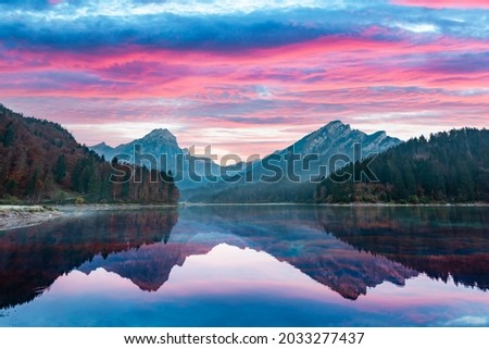 Peaceful autumn view on Obersee lake in Swiss Alps. Dramatic sunset sky and mountains reflections in clear water. Nafels village, Switzerland. Landscape photography