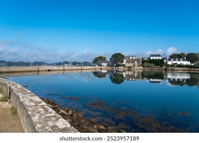 Peaceful coastal houses reflected in water on Île de Saint-Cado - Powered by Shutterstock