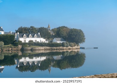 Peaceful coastal houses reflected in water on Île de Saint-Cado - Powered by Shutterstock