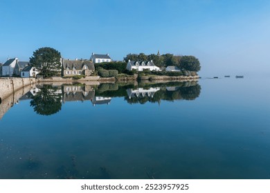 Peaceful coastal houses reflected in water on Île de Saint-Cado - Powered by Shutterstock