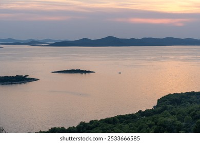 Peaceful coastal landscape with calm sea at sunset and distant green islands on the horizon. Concept of natural beauty, calmness, and the soothing effect of ocean views. High quality photo - Powered by Shutterstock