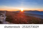 Peaceful colorful time when sun rises over the mountain ridge  and first sun rays touches the frozen nordic like nature on the morning high in the Krkonose mountains during autumn. Czech republic