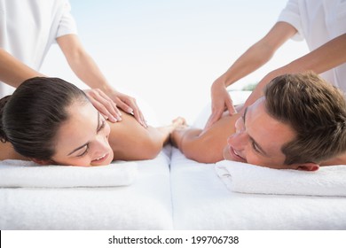 Peaceful Couple Enjoying Couples Massage Poolside Outside At The Spa