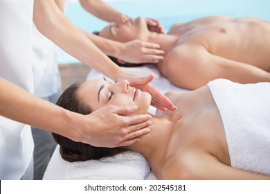 Peaceful Couple Enjoying Couples Massage Poolside Outside At The Spa