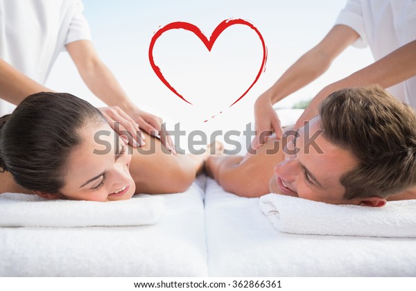 Peaceful couple enjoying couples massage poolside\
against heart