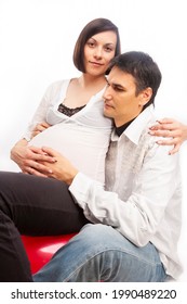 Peaceful Dreaming Caucasian Couple with Pregnant Woman Sitting Embraced Against White Background. Vertical Composition - Shutterstock ID 1990489220