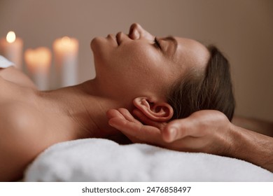 Peaceful female face at massage session in spa center - Powered by Shutterstock