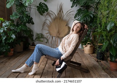 Peaceful Girl Florist Relax On Comfortable Chair With Eyes Closed Sleeping Resting In Greenhouse After 3d Gaming Or Online Shopping. Female Feel Fatigue Fall Asleep After Using Virtual Reality Headset