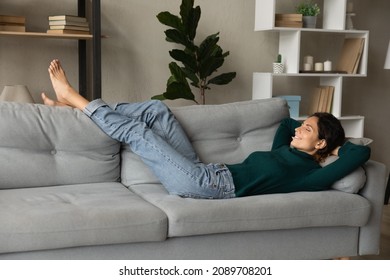 Peaceful Hispanic Woman Relax Rest On Comfortable Couch At Home Sleep Or Daydream With Eyes Closed. Calm Latino Female Renter Lying On Sofa In Living Room Take Nap Relieve Negative Emotions.