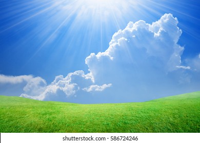 Peaceful idyllic background - beautiful blue sky with bright sun and white clouds, light from heaven, green grass field - Shutterstock ID 586724246