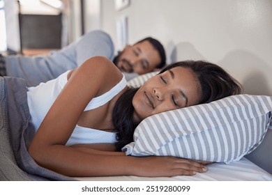 A peaceful indian couple sleeping side by side in bed with grey blanket. A serene moment of a middle eastern young woman and her partner asleep in cozy bedroom.  - Powered by Shutterstock