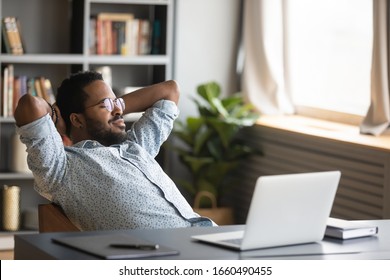 Peaceful Millennial African American Freelance Man In Glasses Chilling On Cozy Chair, Daydreaming Alone At Home. Sleepy Young Biracial Businessman Napping Alone At Workplace, Enjoying Break Time.