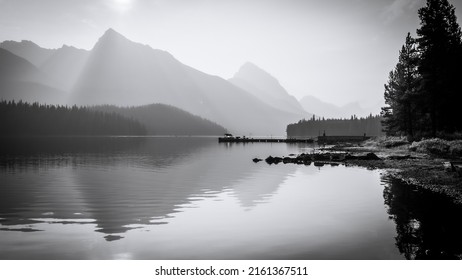 Peaceful morning on an alpine lake surrounded by mountains, monochromatic, Jasper NP, Canada