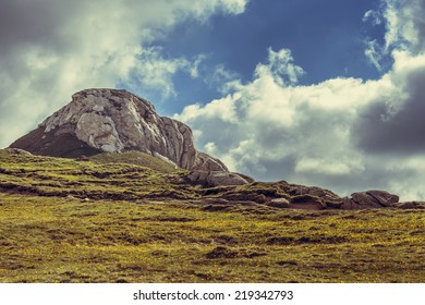 Peaceful mountain landscape with rocky heights and grasslands in Bucegi mountains, Romania.