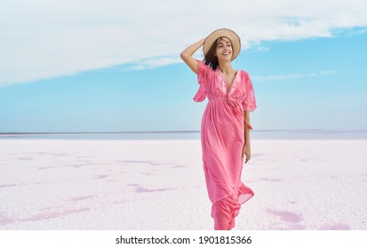 Peaceful Paradise Vacation Woman Walking On Salt Flats Beach With Blue Sky, Tranquility And Serenity Image. Girl In Pink Dress And Hat Feeling Good