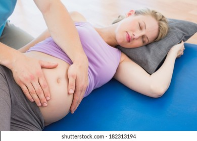 Peaceful pregnant woman having a relaxing massage in a studio - Powered by Shutterstock