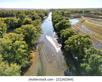 Peaceful River Running Between Brilliant Green Trees.