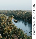 A peaceful scene of Kerala’s backwaters in India, with a houseboat surrounded by palm trees and calm water.