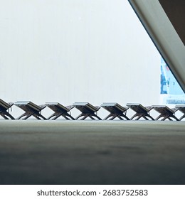 A peaceful scene inside a mosque, capturing several Quran stands neatly arranged and prepared for worshippers, The wooden stands, often intricately carved, await the holy books