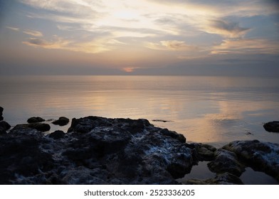 Peaceful seascape at sunset. Calm sea.Rocky sea coast at sunset. Nature in warm summer tones. - Powered by Shutterstock