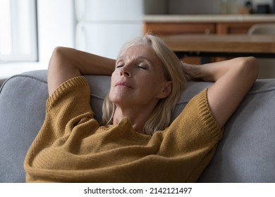 Peaceful sleepy middle aged woman resting on sofa with closed eyes, falling asleep, enjoying break, silent leisure time at home, taking deep breath of fresh air, reducing stress - Powered by Shutterstock