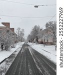 A peaceful snow-covered street in a quiet neighborhood, surrounded by homes blanketed in soft, fresh snow. 