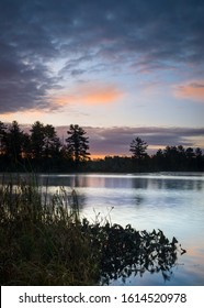 A peaceful start to an autumn day as sunrise colors creep across the sky over a secluded Northwoods lake.  Oneida County, Wisconsin. 