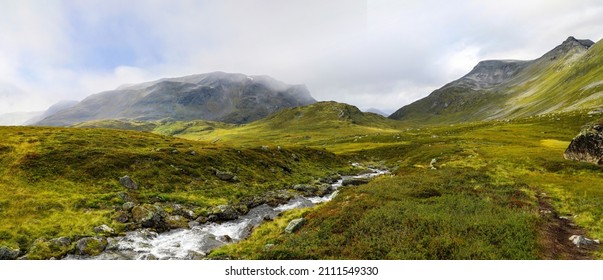 Peaceful stream flowing through a green mountain landscape - Shutterstock ID 2111549330