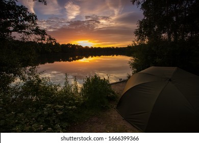 Peaceful Sunset carp fishing session. Golden sky and calm water