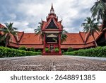 A peaceful view of the National Museum of Cambodia in Phnom Penh, featuring traditional Khmer architecture, red-tiled roofs, and a central courtyard statue. 