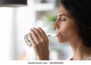 Peaceful woman satisfying thirst, drinking fresh pure clear cold water, enjoying beverage with closed eyes, keeping healthy hydration, aqua balance, diet, losing weight, practicing detox - Shutterstock ID 2062830305