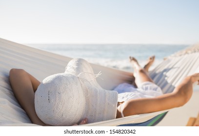 Peaceful woman in sunhat relaxing on hammock at the beach - Powered by Shutterstock